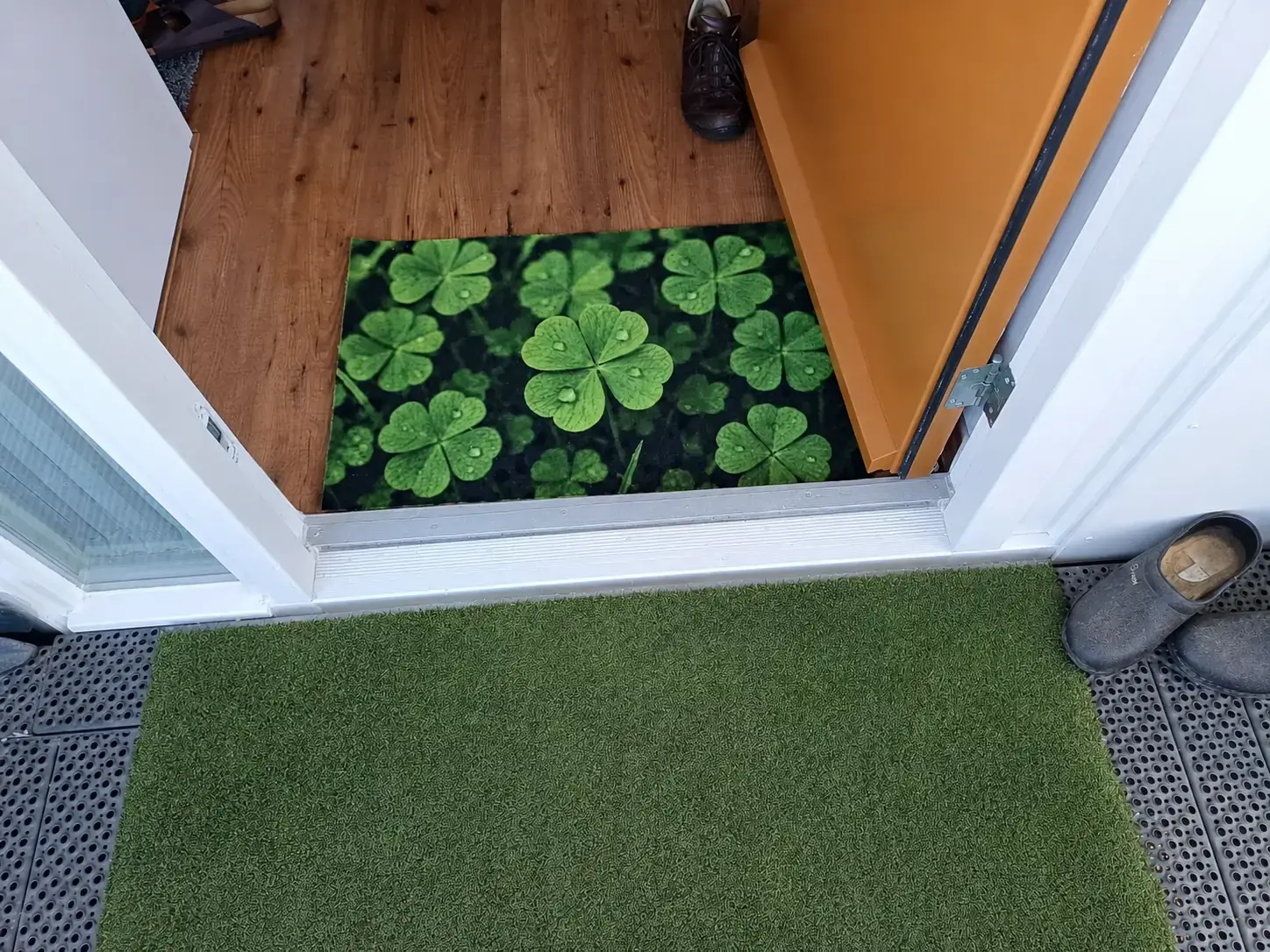 Schoonloopmat met klavertje-vier fotoprint in de voordeur van een woning